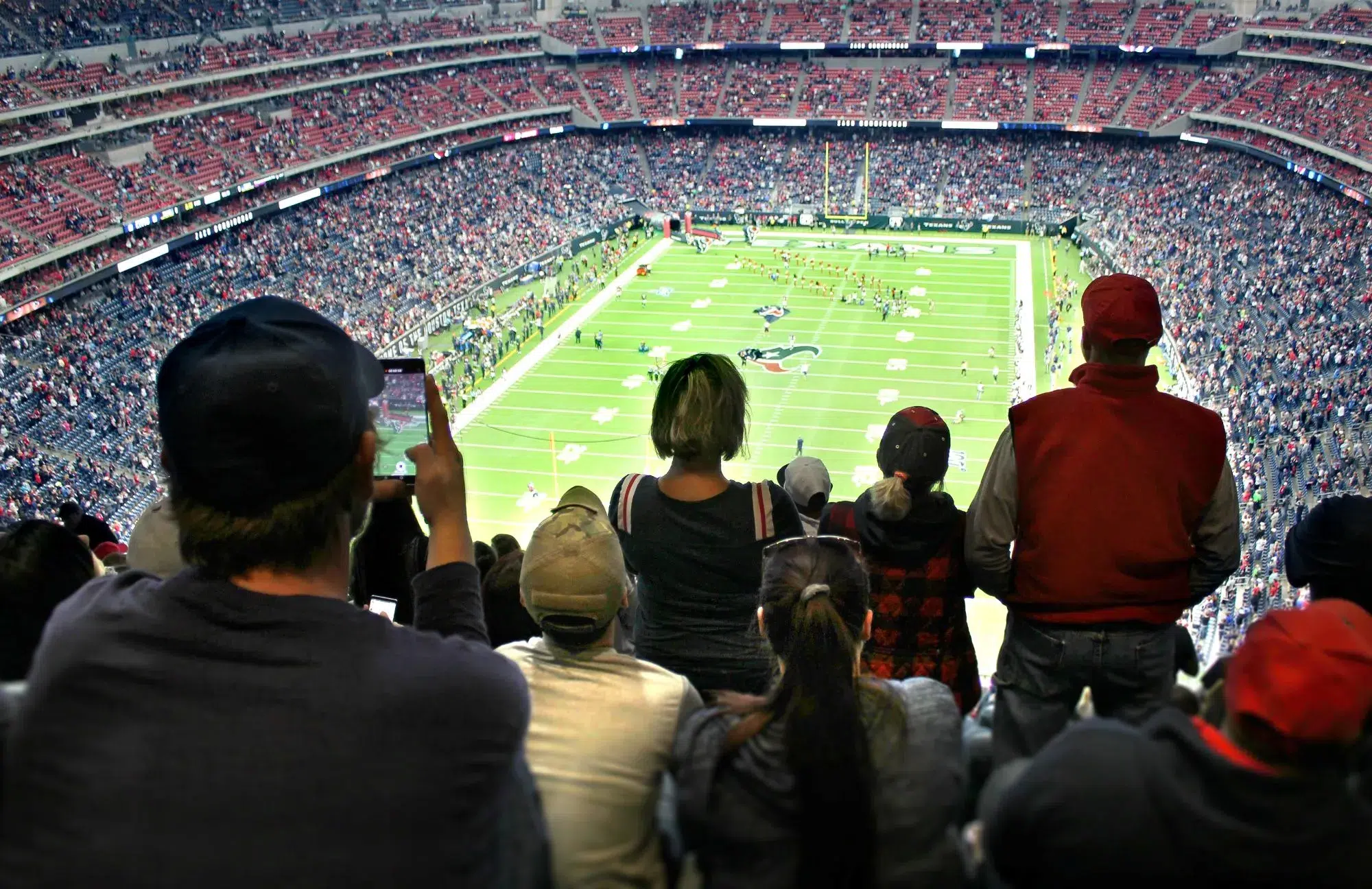 Excited fans cheer in a packed stadium during an intense NFL Super Bowl game