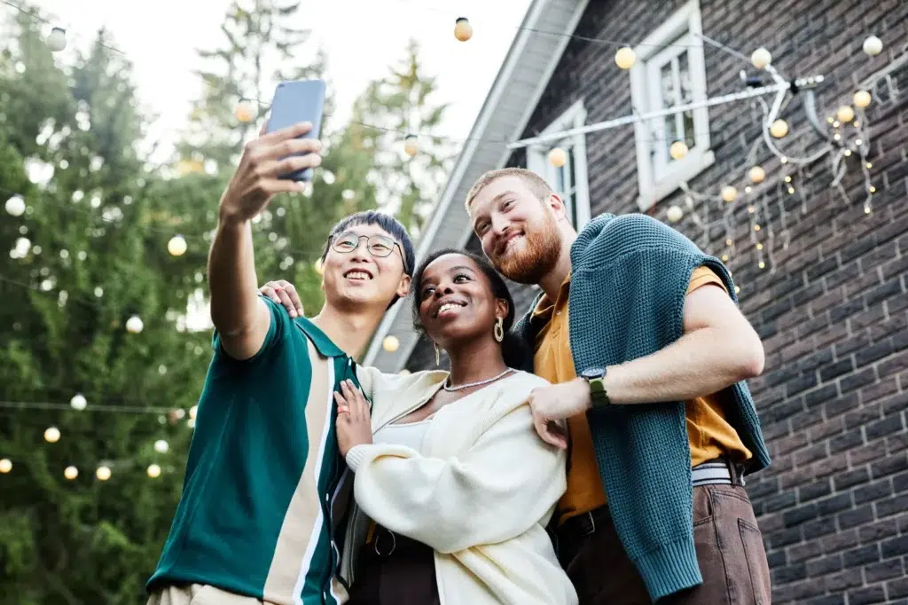 Group of diverse friends taking a selfie at an outdoor event, representing social proof in marketing